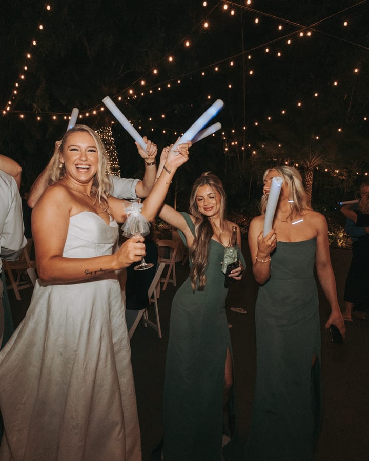 Guests dancing under string lights at a night wedding reception
