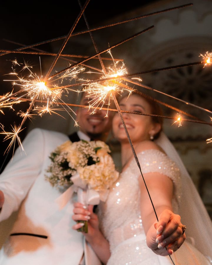 A couple celebrating with sparklers on their wedding night