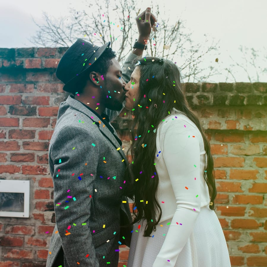 A couple kissing in a shower of confetti