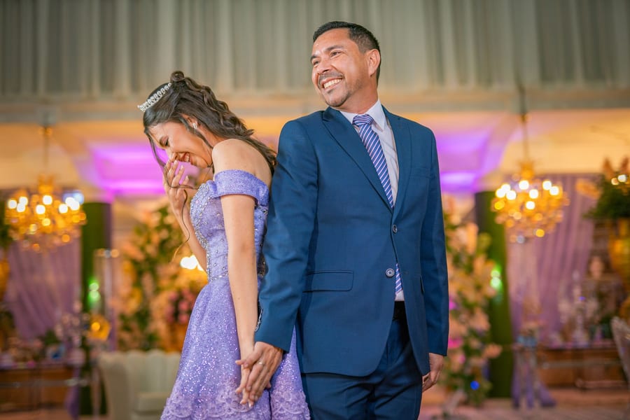 A couple standing back to back at their reception